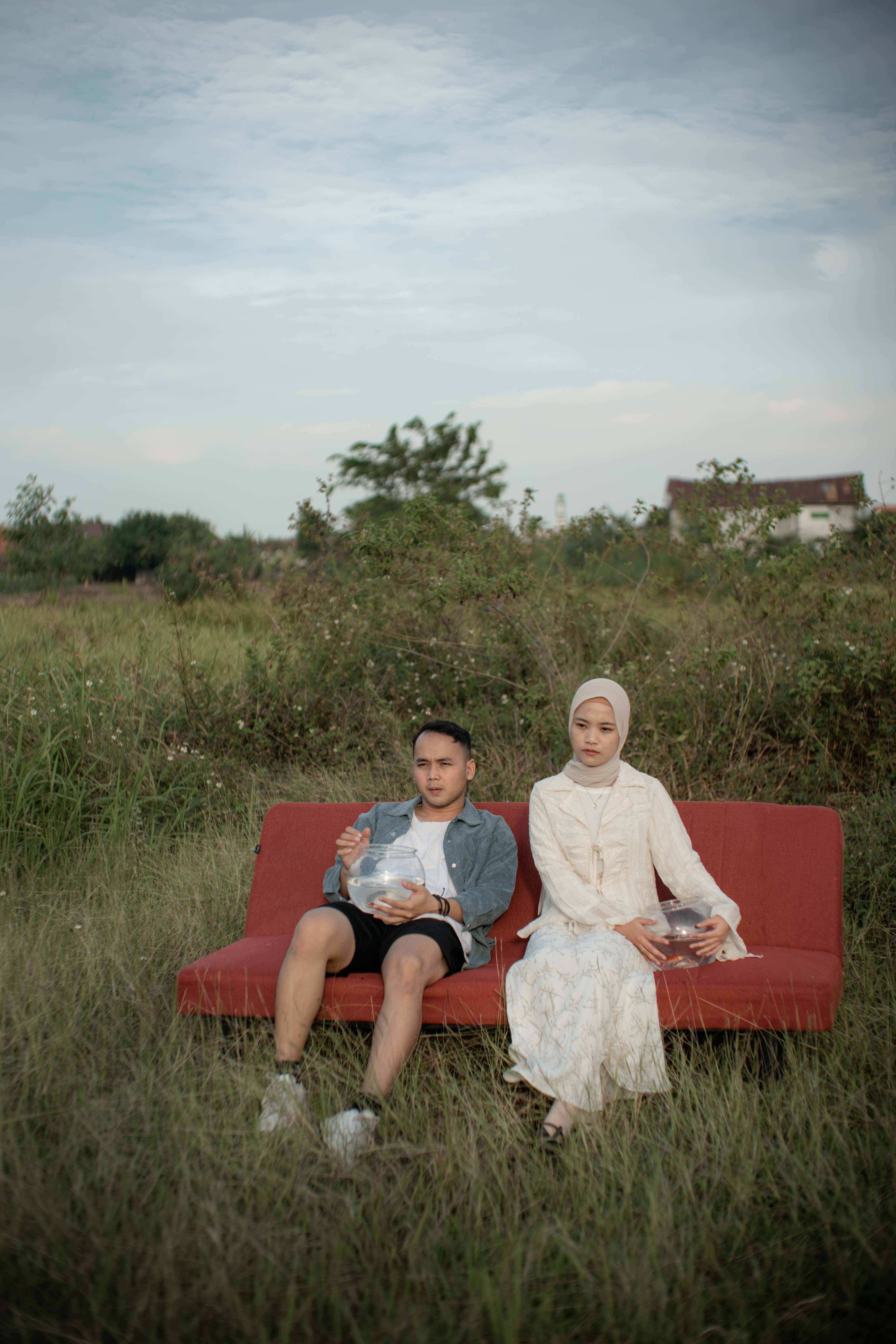 Pasangan duduk di sofa di lapangan